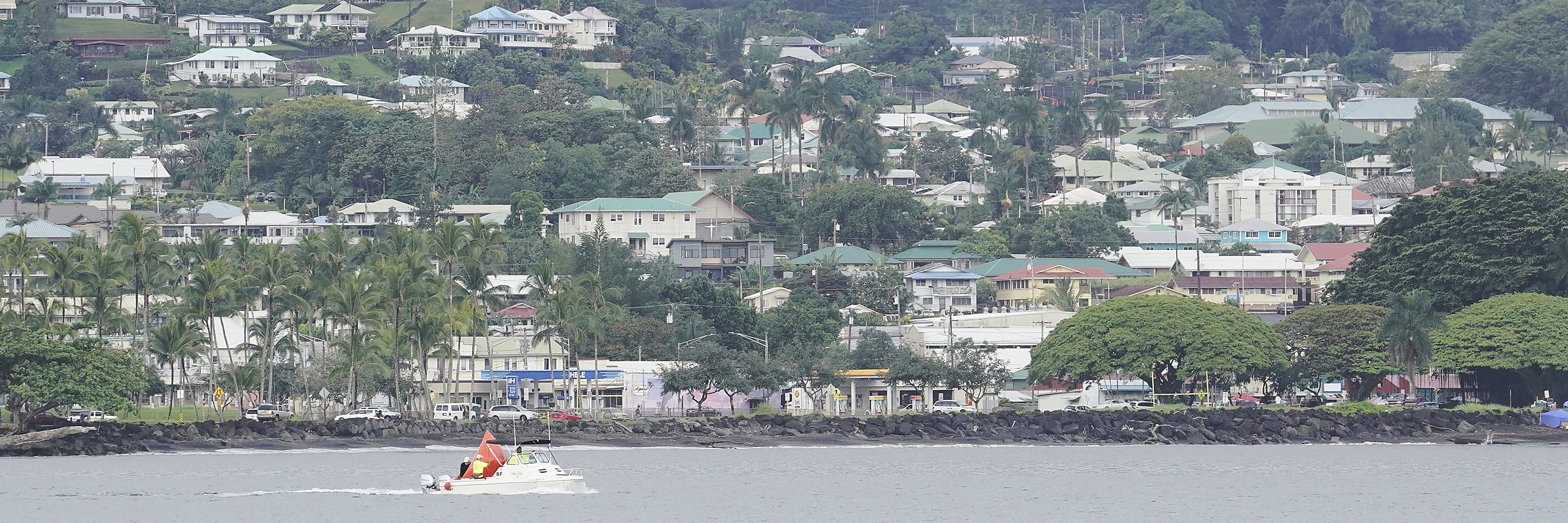 A small craft crosses in front of Hilo town on the island of Hawaii